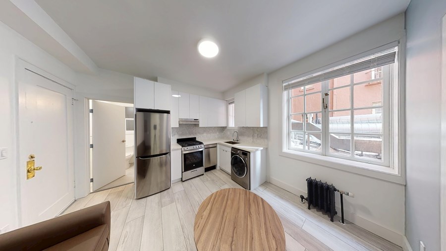 A modern kitchen with a wooden table and chairs.